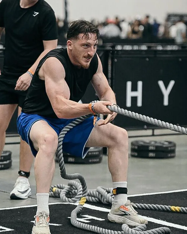 Coach René pulling the sled rope at a HYROX competition